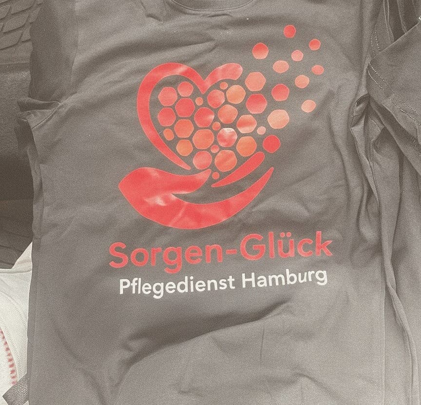 Dienstkleidung von Sorgen-Glück Pflegedienst Hamburg: das Logo zeigt eine offene Hand, die ein aus Zellen gebautes Herz trägt